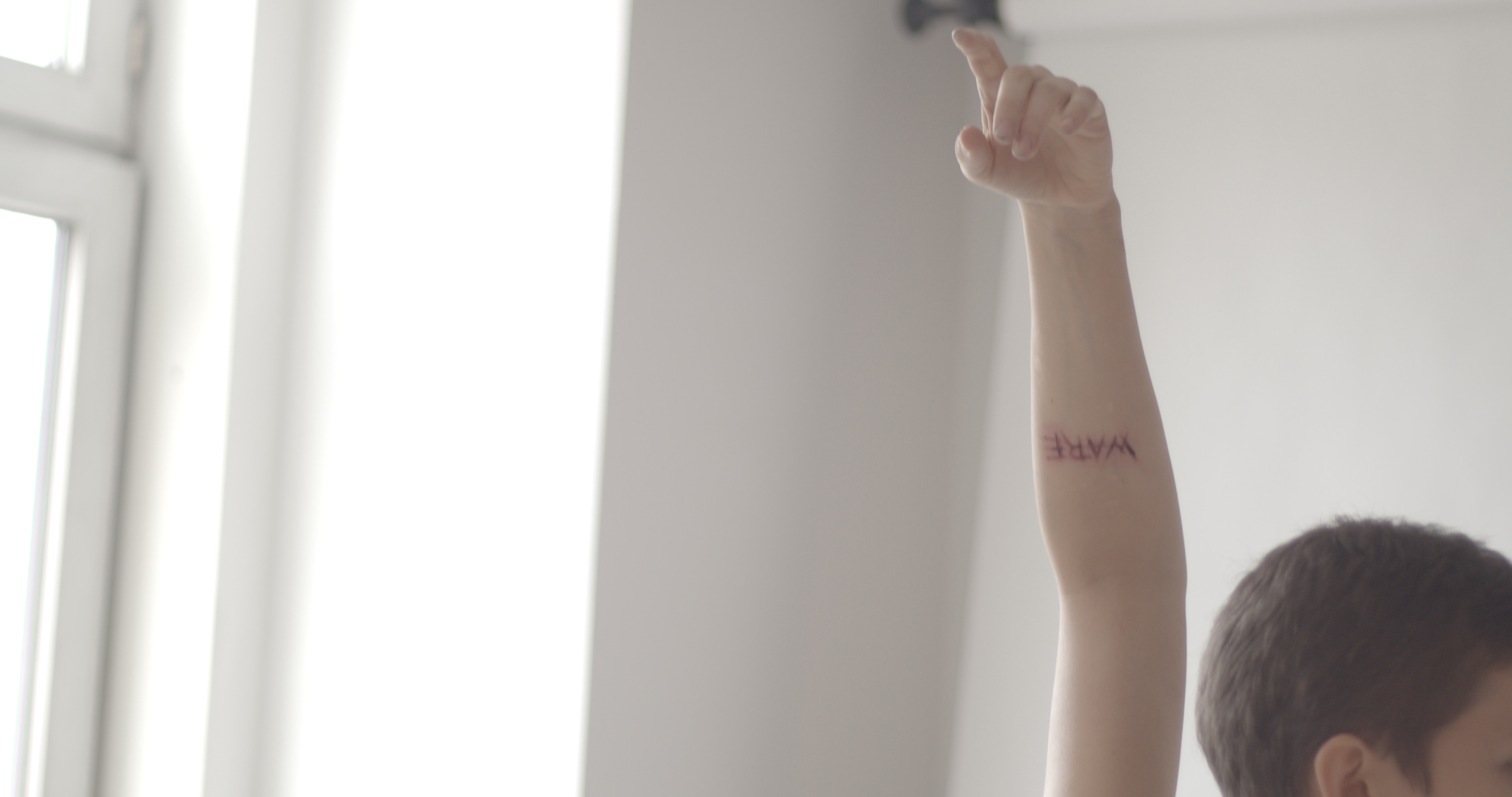 Still from a Making-Of video of a photoshooting depicting 'ware' meaning product written on female bodies. by f-land