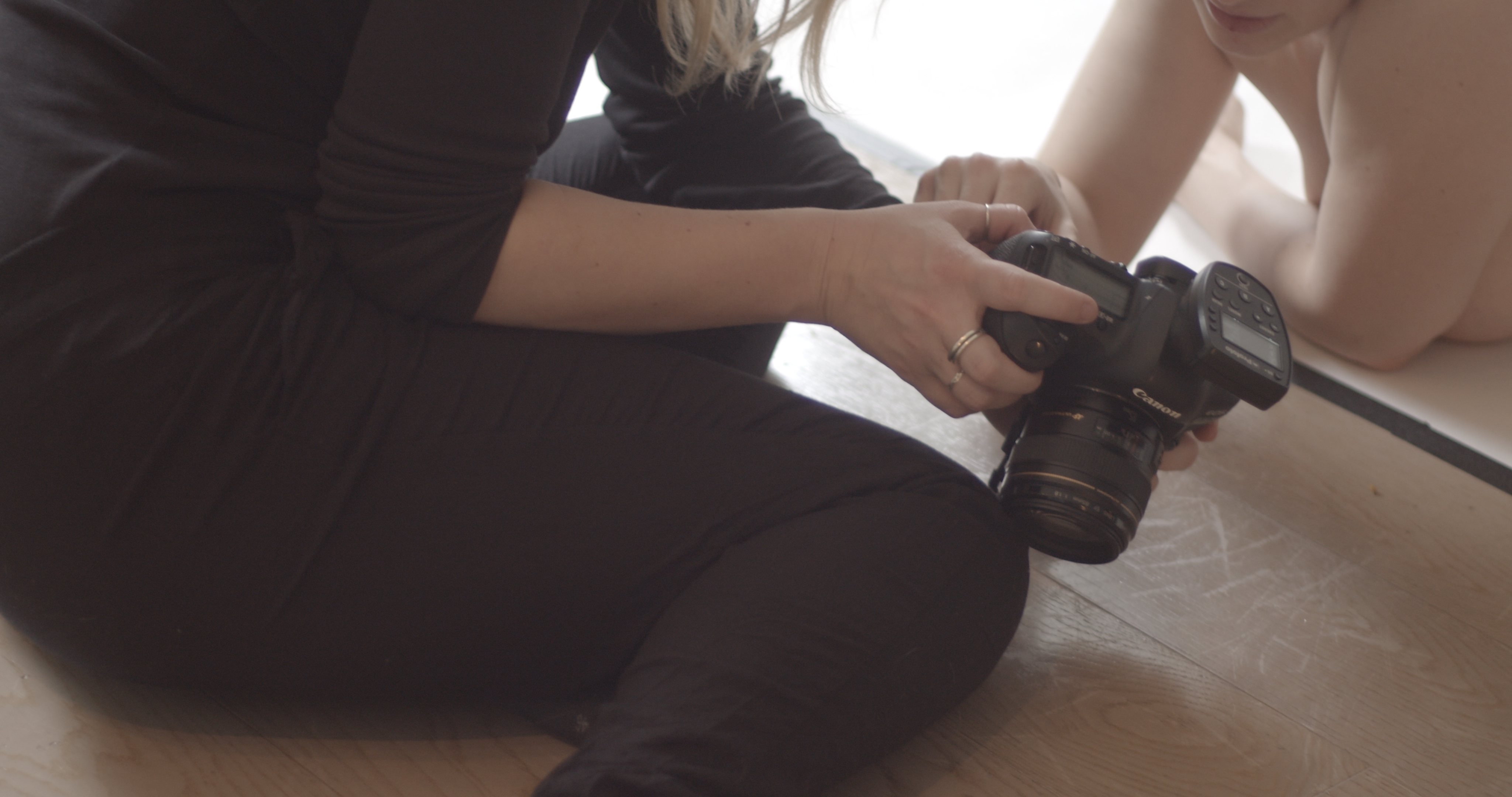 Photographer. Still from a Making-Of video of a photoshooting depicting 'ware' meaning product written on female bodies. by f-land